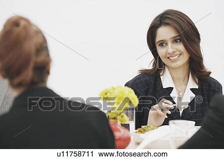 Two businesswomen eating together View Large Photo Image Stock Image - Two businesswomen eating together. Fotosearch