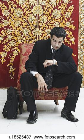 Stock Photo - Businessman looking at his wristwatch. Fotosearch