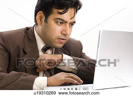 Stock Photo - Close-up of a businessman using a laptop. Fotosearch