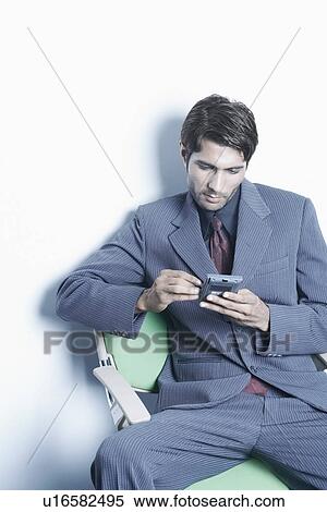 Stock Photography - High angle view of a businessman using a personal data assistant. Fotosearch