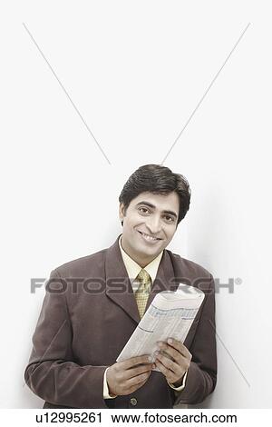 Stock Image - Portrait of a businessman holding a newspaper. Fotosearch