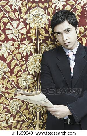 Stock Photo - Portrait of a businessman holding a newspaper. Fotosearch
