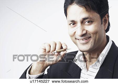 Stock Photo - Portrait of a businessman holding a cigar. Fotosearch