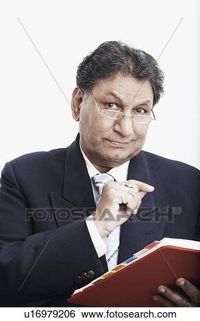 Stock Photograph - Portrait of a businessman holding a personal organizer. Fotosearch