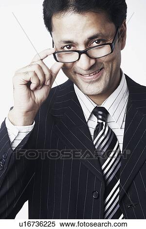 Portrait of a businessman peeping over his eyeglasses View Large Photo Image Stock Photography - Portrait of a businessman peeping over his eyeglasses. Fotosearch