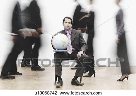 Portrait of a businessman sitting in a meeting holding a globe View Large Photo Image Stock Image - Portrait of a businessman sitting in a meeting holding a globe. Fotosearch