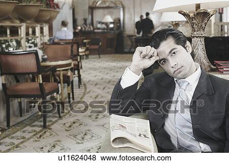 Portrait of a businessman sitting in a hotel lobby View Large Photo Image Stock Photo - Portrait of a businessman sitting in a hotel lobby. Fotosearch