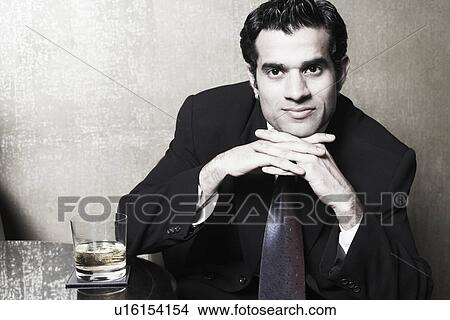 Picture - Portrait of a businessman thinking with his hands under his chin. Fotosearch
