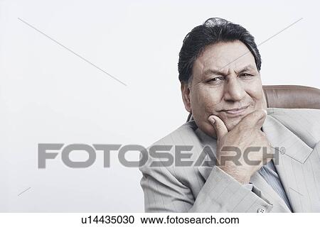 Stock Image - Portrait of a businessman with his hand on his chin. Fotosearch