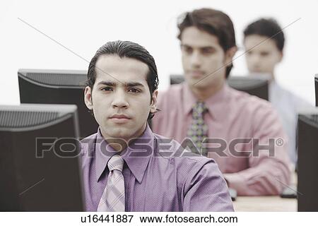 Stock Photo - Business executives working on computers in an office. Fotosearch
