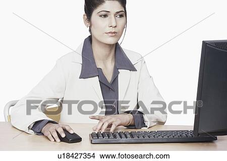 Close-up of a businesswoman sitting in front of a computer View Large Photo Image Picture - Close-up of a businesswoman sitting in front of a computer. Fotosearch