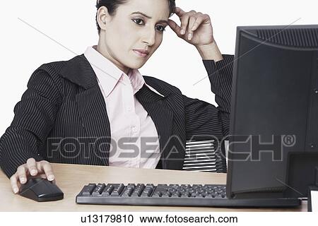 Close-up of a businesswoman sitting in front of a computer View Large Photo Image Stock Image - Close-up of a businesswoman sitting in front of a computer. Fotosearch