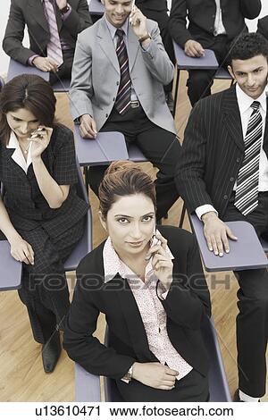 Stock Image - High angle view of business executives talking on mobile phones. Fotosearch
