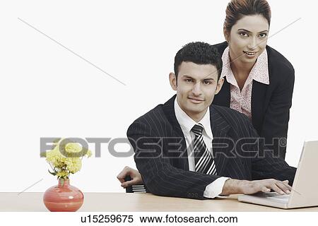 Portrait of a businessman and a businesswoman using a laptop View Large Photo Image Stock Photography - Portrait of a businessman and a businesswoman using a laptop. Fotosearch