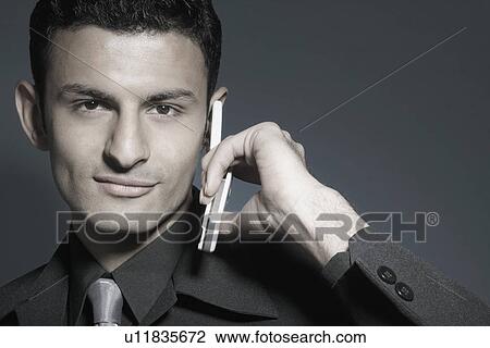 Portrait of a businessman holding a mobile phone View Large Photo Image Stock Image - Portrait of a businessman holding a mobile phone. Fotosearch