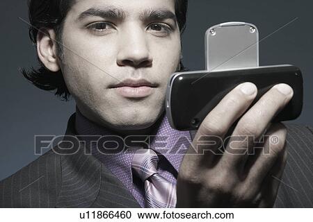 Stock Image - Portrait of a businessman holding a mobile phone. Fotosearch