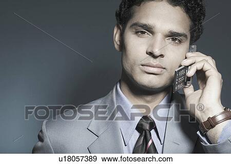 Portrait of a businessman holding a mobile phone View Large Photo Image Stock Photo - Portrait of a businessman holding a mobile phone. Fotosearch