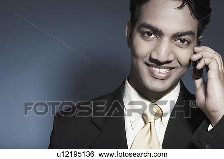 Stock Photograph - Portrait of a businessman holding a mobile phone. Fotosearch