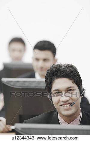 Stock Image - Portrait of a businessman wearing a headset. Fotosearch