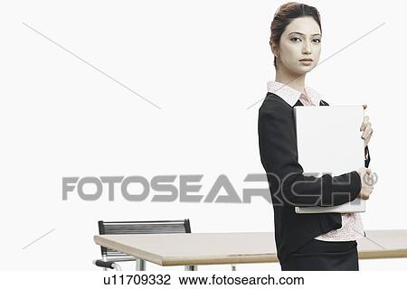 Stock Image - Portrait of a businesswoman holding a laptop. Fotosearch