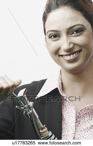 Stock Photography - Portrait of a businesswoman opening a champagne bottle. Fotosearch