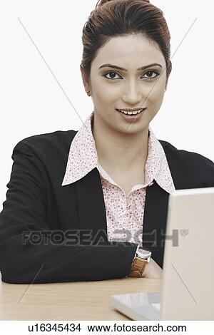 Picture - Portrait of a businesswoman sitting in front of a laptop. Fotosearch