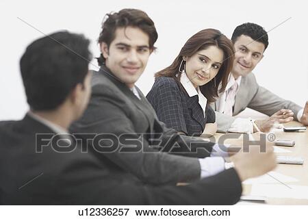 Three businessmen and a businesswoman sitting in a meeting View Large Photo Image Stock Photo - Three businessmen and a businesswoman sitting in a meeting. Fotosearch