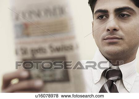 Close-up of a businessman holding a newspaper View Large Photo Image Stock Photo - Close-up of a businessman holding a newspaper. Fotosearch
