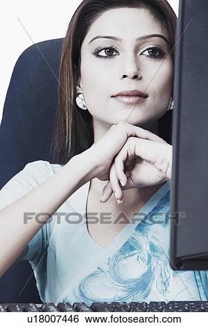 Close-up of a businesswoman looking at a computer monitor View Large Photo Image Stock Photograph - Close-up of a businesswoman looking at a computer monitor. Fotosearch