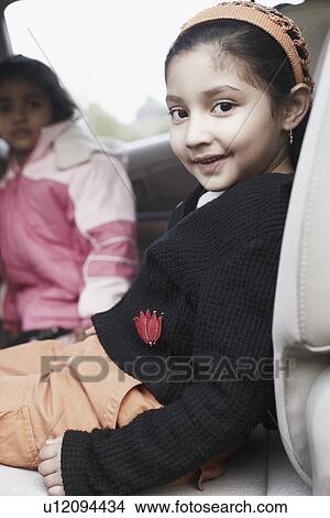 Close-up of a girl and her sister sitting in a car View Large Photo Image Picture - Close-up of a girl and her sister sitting in a car. Fotosearch