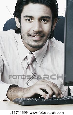 Stock Photo - Portrait of a businessman using a computer. Fotosearch