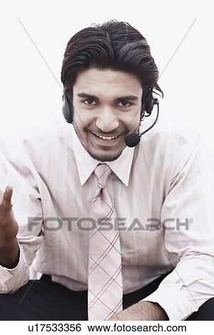 Stock Photograph - Portrait of a businessman wearing a hands free device. Fotosearch