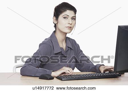 Portrait of a businesswoman sitting in front of a computer View Large Photo Image Stock Image - Portrait of a businesswoman sitting in front of a computer. Fotosearch