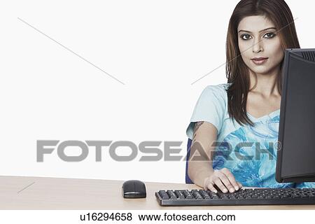 Stock Photo - Portrait of a businesswoman sitting in front of a computer. Fotosearch
