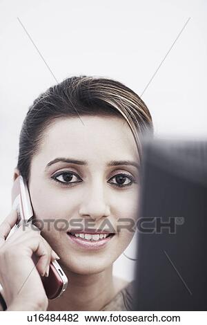 Stock Image - Portrait of a businesswoman talking on a mobile phone. Fotosearch