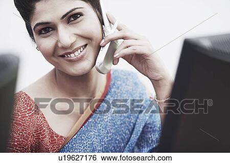Stock Photograph - Portrait of a businesswoman talking on a mobile phone. Fotosearch