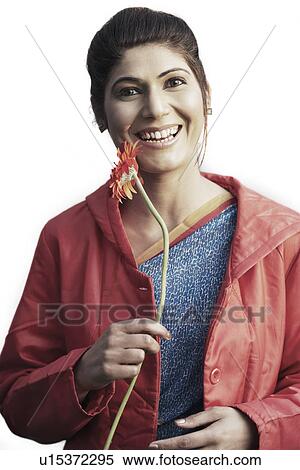 Portrait of a young woman holding a daisy View Large Photo Image Stock Photography - Portrait of a young woman holding a daisy. Fotosearch