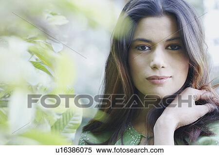 Stock Photography - Portrait of a young woman with her hand in her hair. Fotosearch