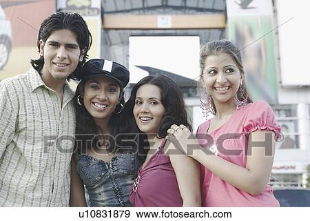 Close-up of a young man and three young women smiling View Large Photo Image Stock Photo - Close-up of a young man and three young women smiling. Fotosearch