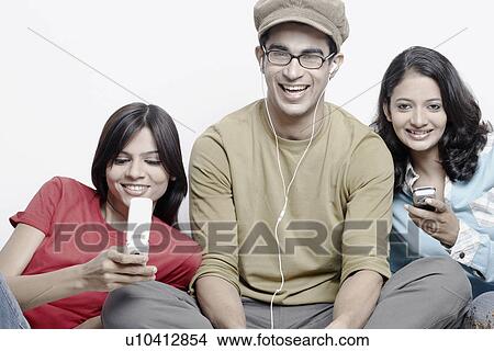 Picture - Close-up of a young man sitting between two young women. Fotosearch