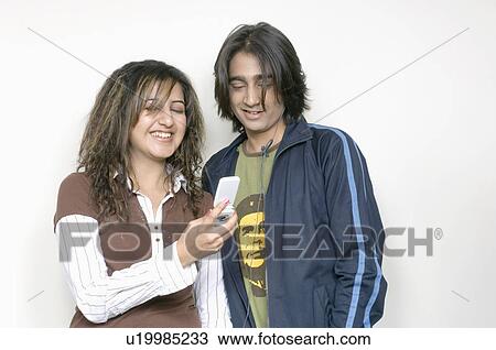 Close-up of a young woman and a young man looking at a mobile phone View Large Photo Image Stock Image - Close-up of a young woman and a young man looking at a mobile phone. Fotosearch
