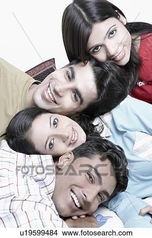 Close-up of two young men and two young women smiling View Large Photo Image Picture - Close-up of two young men and two young women smiling. Fotosearch