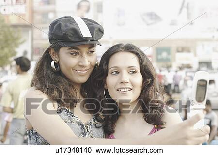 Close-up of two young women taking a photograph of themselves View Large Photo Image Stock Image - Close-up of two young women taking a photograph of themselves. Fotosearch