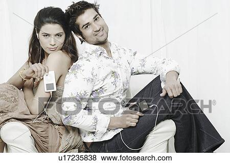 Portrait of a young couple listening to an MP3 players View Large Photo Image Stock Photo - Portrait of a young couple listening to an MP3 players. Fotosearch