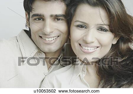 Stock Image - Portrait of a young couple smiling. Fotosearch