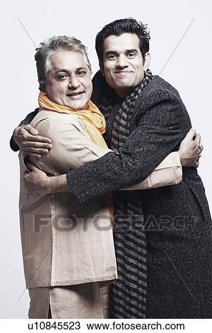 Stock Image - Portrait of a young man hugging his father. Fotosearch