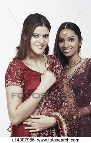 Portrait of a young woman standing with a teenage girl View Large Photo Image Stock Photograph - Portrait of a young woman standing with a teenage girl. Fotosearch