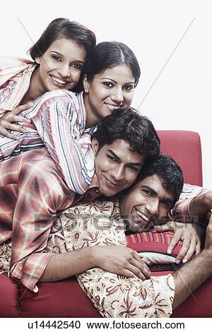 Portrait of two young men and two young women lying on top of each other smiling View Large Photo Image Stock Image - Portrait of two young men and two young women lying on top of each other smiling. Fotosearch