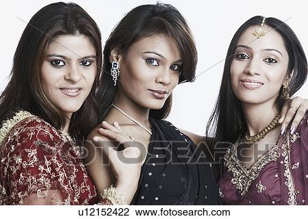 Stock Image - Portrait of two young women and a teenage girl smiling. Fotosearch
