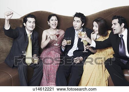 Stock Image - Three young men and two young women holding glasses. Fotosearch